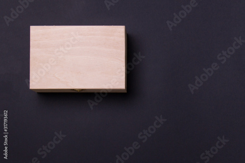 wood box lying on black background in left corner, top view with copy space