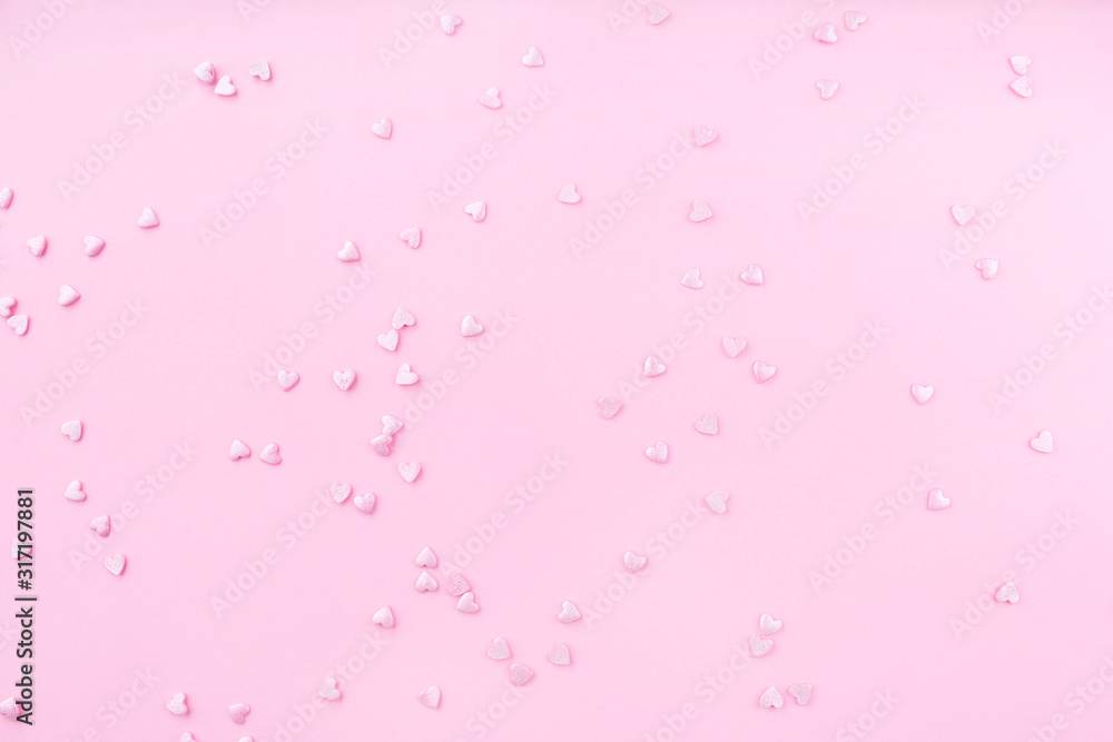Pink background. Pink hearts on a pink background. Hearts sprinkles. Valentine day. Flat lay style. Top view. Place for design. Sweet background. Confetti.