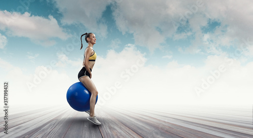 Sporty woman on fitness ball. Mixed media © Sergey Nivens