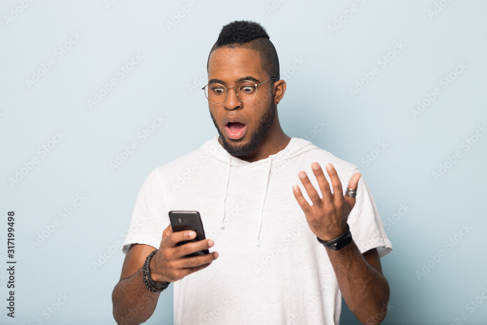 Surprised african American man get unexpected message on cellphone Surprised african American man get unexpected message on cellphone