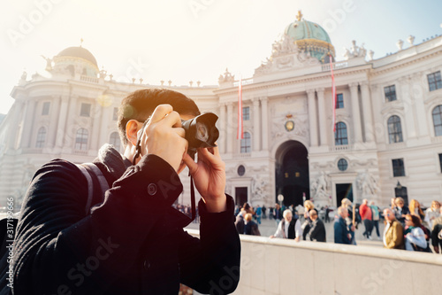 Photography Young Asian man tourist taking photos with camera in hands near Hofburg palace in Vienna, Austria, Europe