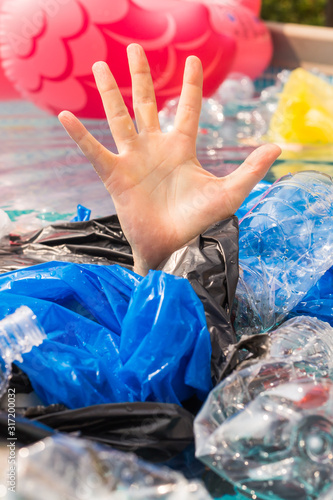 Plastic pollution and environmental problem, man's hand in plastic sea