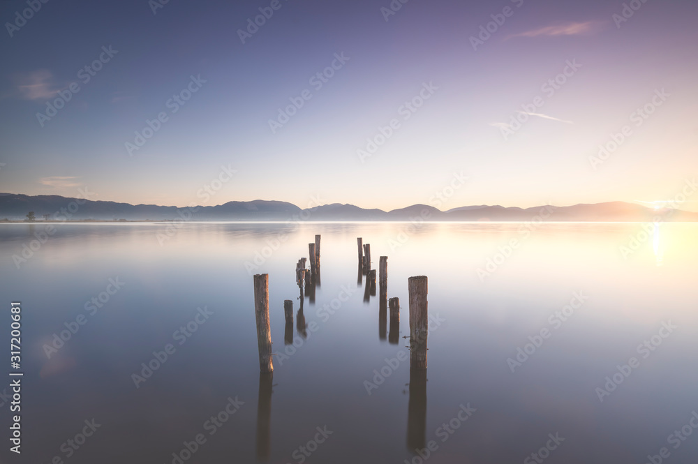 Wooden pier or jetty remains and lake at sunrise. Torre del lago Puccini Versilia Tuscany, Italy
