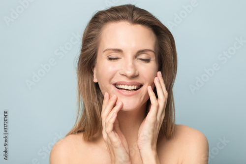 Happy beautiful woman smile touching clean face skin