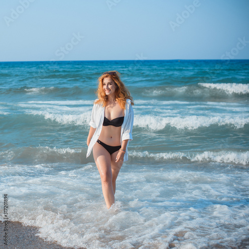 Plus size nice young woman with full hips and pretty figure in fashionable swimsuit rest at sea, vacation and trip concept