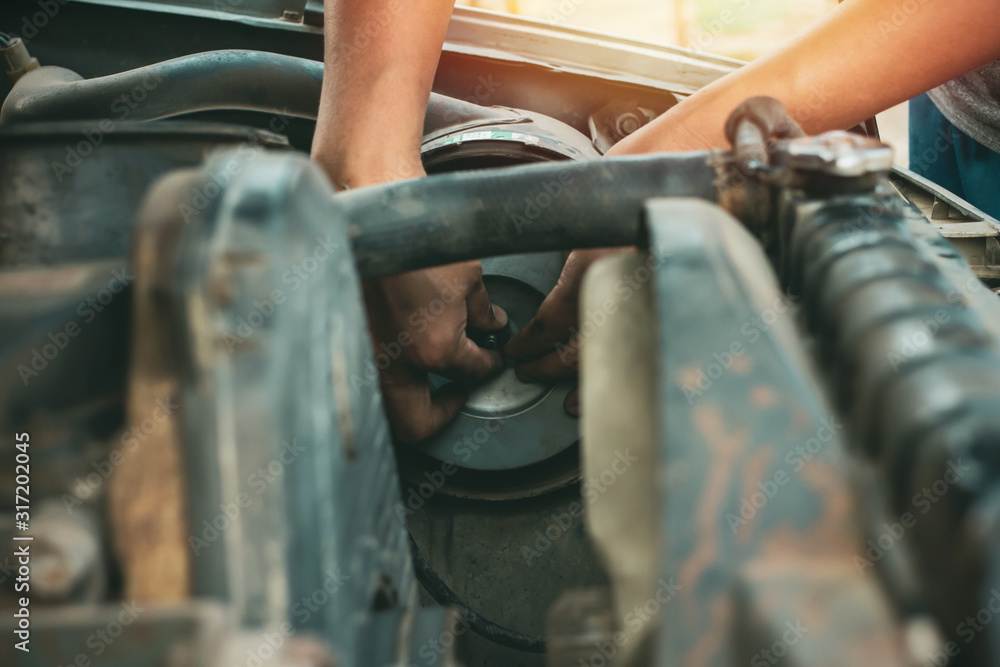 Young mechanic working use a wrench and fixing old car Young mechanic working use a wrench and fixing old car