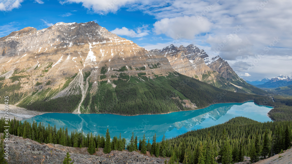 Beautiful turquoise waters of the Peyto Lake with snow-covered peaks above it in Rocky Mountains, Banff National Park, Canada.