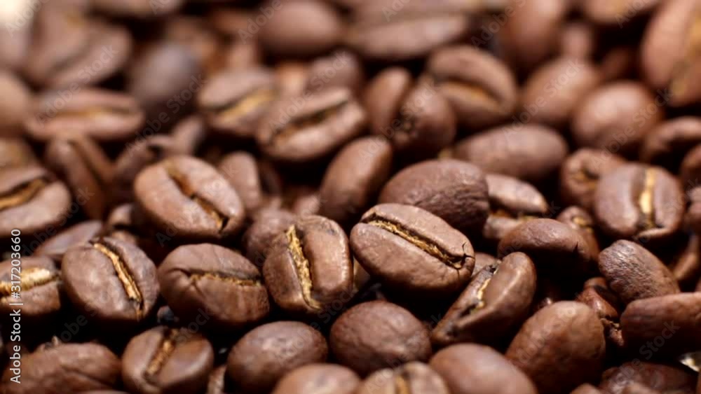 Premium quality light roasted coffee beans rotating. Close up of brown roasted coffee beans. Arabica coffee beans slowly spin. Premium quality light roasted coffee beans rotating. Close up of brown roasted coffee beans. Arabica coffee beans slowly spin.