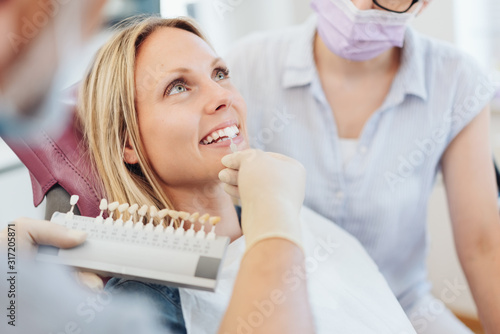 Dentist checking the whiteness of a patients teeth photo
