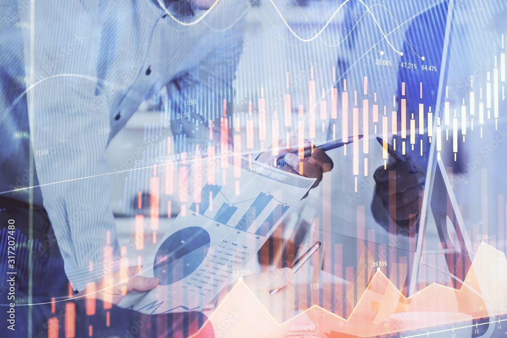 Double exposure of chart with businessman typing on computer in office on background. Concept of hard work.