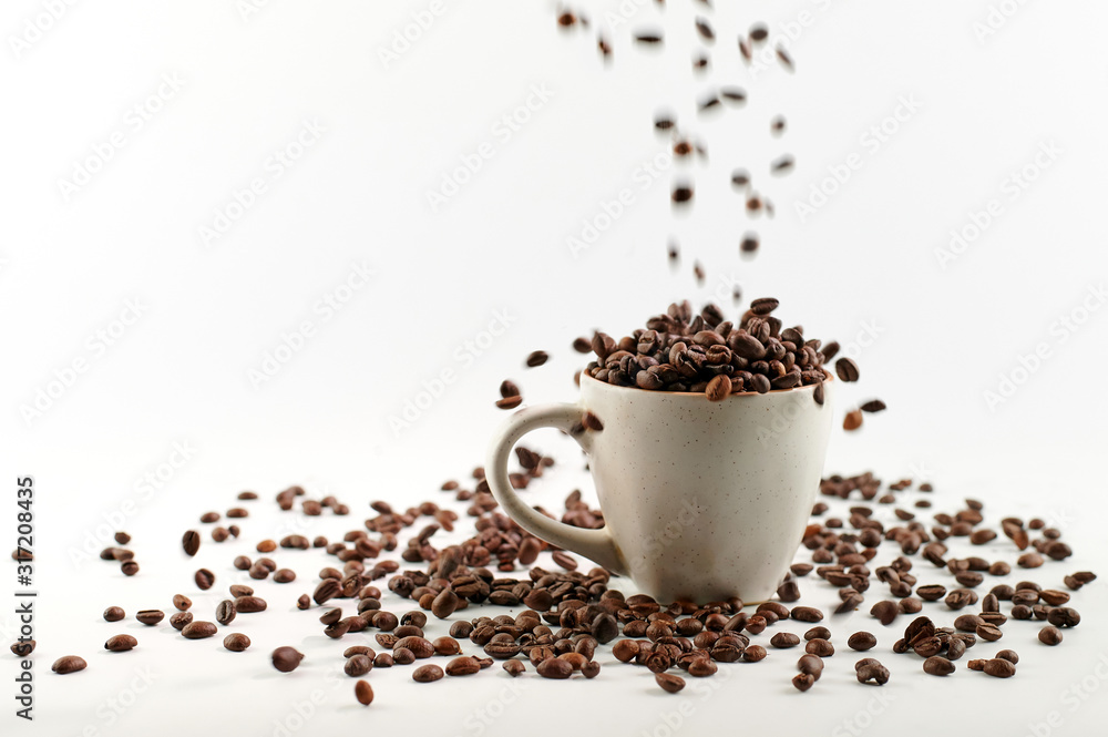 coffee beans poured into a mug with beans isolated on white coffee beans poured into a mug with beans isolated on white