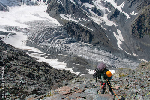 A mountain climber climbs down from the pass by the rope.