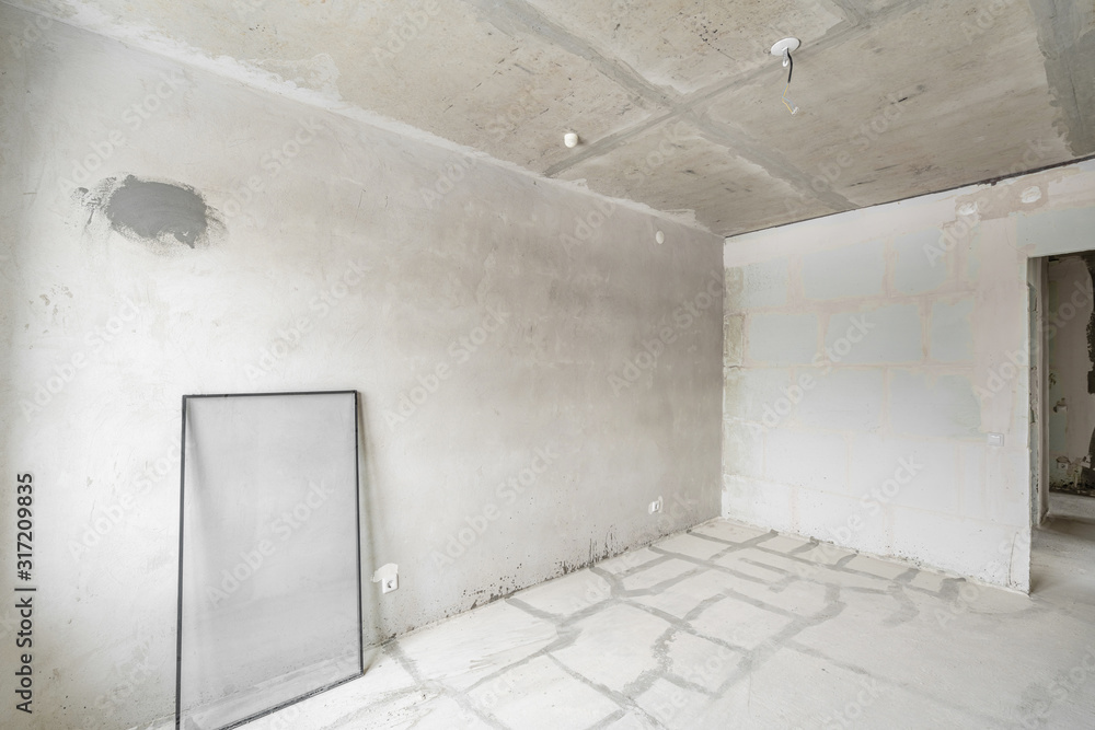 Empty interior for design, gray concrete wall. Empty room. Space for text and picture. Concrete walls, slabs, interior of a new residential building. Partitions in a new apartment. Empty interior for design, gray concrete wall. Empty room. Space for text and picture. Concrete walls, slabs, interior of a new residential building. Partitions in a new apartment.