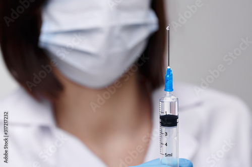 Medical injection,diseases,health care,science,diabetes.Doctor or nurse in hospital holding a syringe with liquid vaccines preparing to do an injection.Medical equipment. People in white uniform,robe.