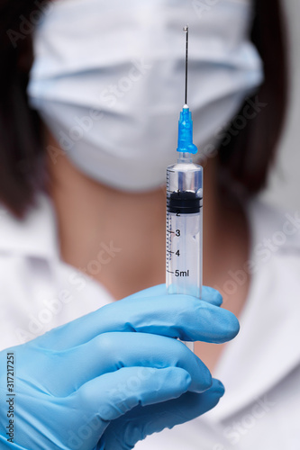 Medical injection diseases health care science diabetes.Doctor or nurse in hospital holding a syringe with liquid vaccines preparing to do an injection.Medical equipment. People in white uniform robe.