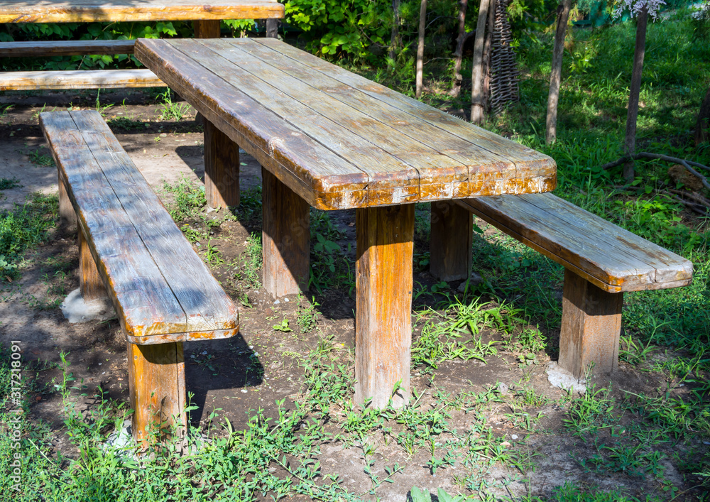 Wooden table and benches in the summer garden Wooden table and benches in the summer garden
