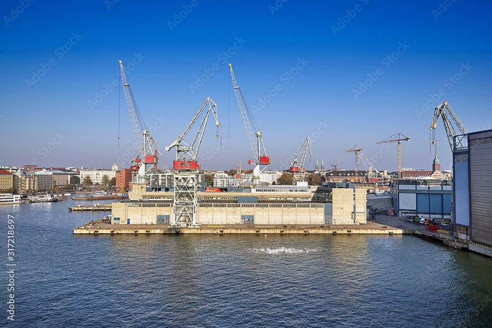 Port cargo dock with cranes on the background of the morning sky