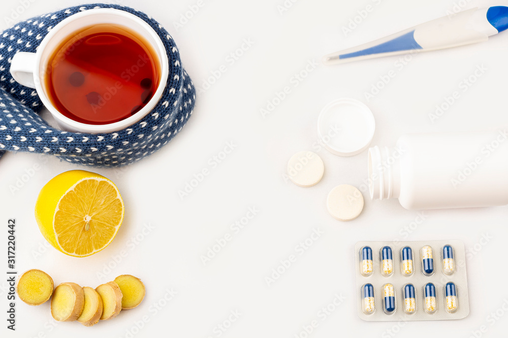 Cup of tea, ginger, lemon and alternative remedies and traditional pills on blue, copy space for text, top view. The concept of seasonal diseases and treatment of colds, flu, heat. Prevention of virus Cup of tea, ginger, lemon and alternative remedies and traditional pills on blue, copy space for text, top view. The concept of seasonal diseases and treatment of colds, flu, heat. Prevention of virus