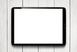 Black tablet computer with blank screen on white wooden background