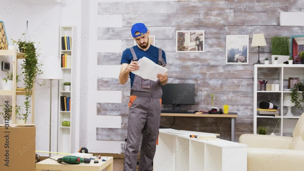 Confused furniture assembly worker while reading instructions Confused furniture assembly worker while reading instructions