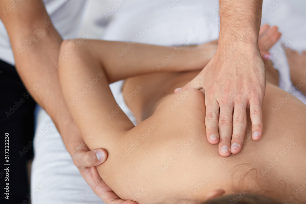 Young beautiful woman enjoying back and shouders massage in spa.Professional massage therapist is treating a female patient in apartment.Relaxation,beauty,body and face treatment concept.Home massage. Young beautiful woman enjoying back and shouders massage in spa.Professional massage therapist is treating a female patient in apartment.Relaxation,beauty,body and face treatment concept.Home massage.