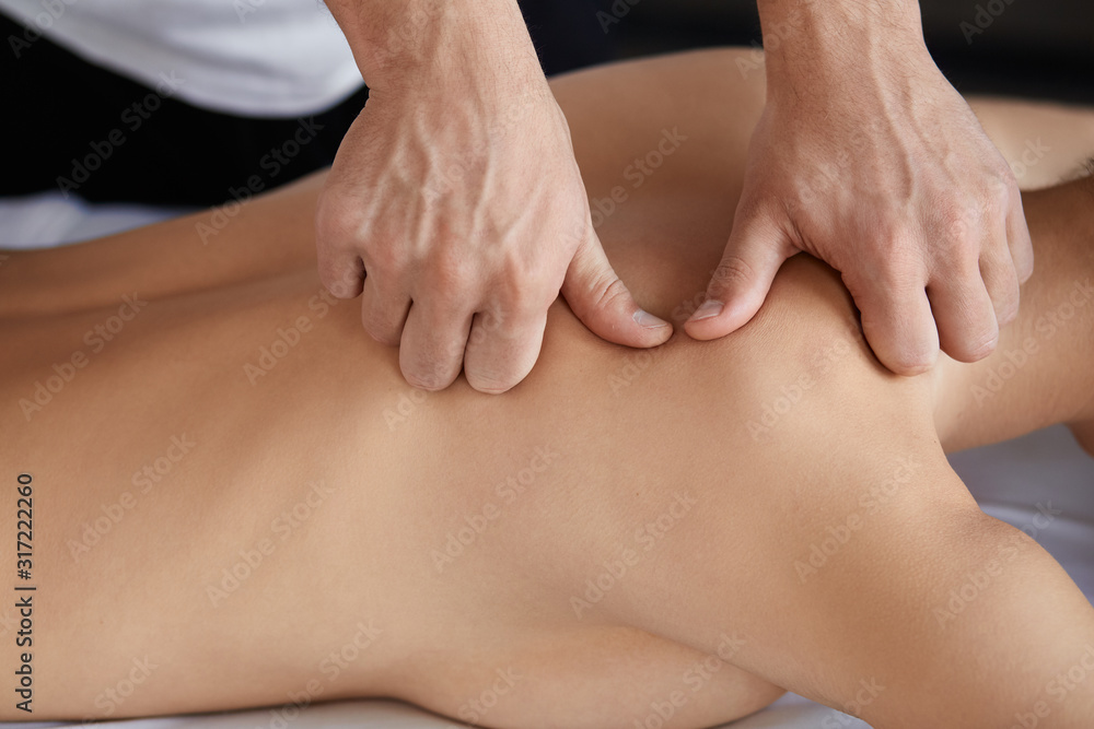 Young beautiful woman enjoying back and shouders massage in spa.Professional massage therapist is treating a female patient in apartment.Relaxation,beauty,body and face treatment concept.Home massage. Young beautiful woman enjoying back and shouders massage in spa.Professional massage therapist is treating a female patient in apartment.Relaxation,beauty,body and face treatment concept.Home massage.