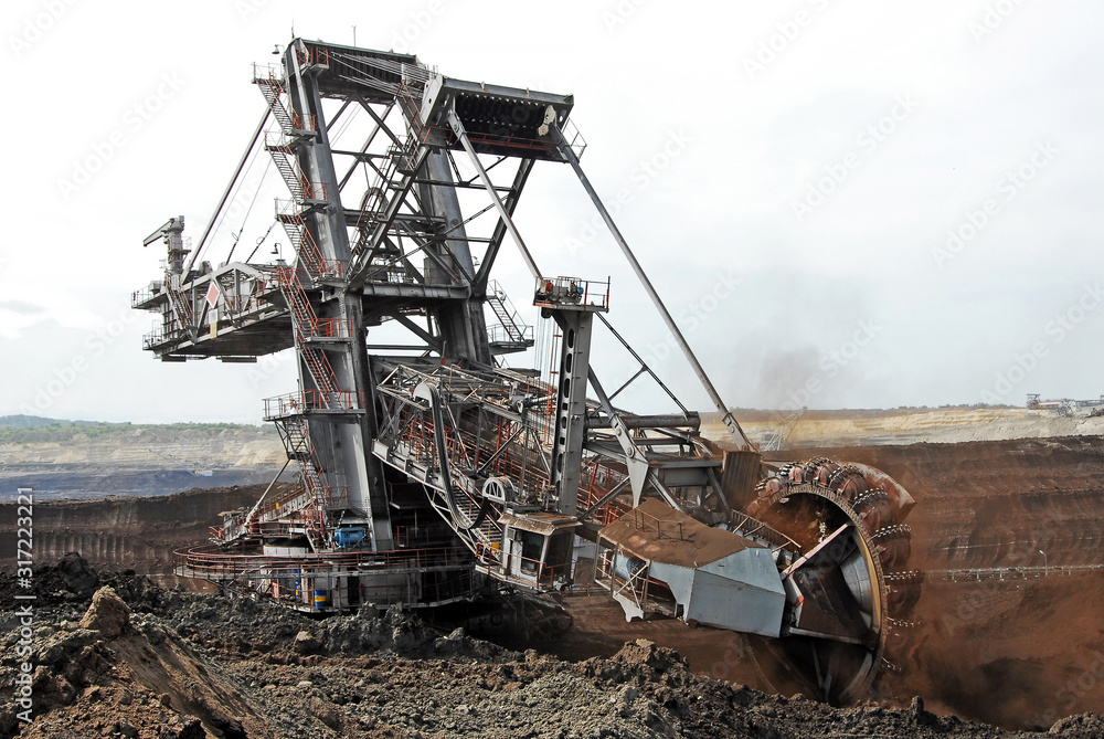 A huge bucket-wheel excavator digging coal on the open-pit mine.	
