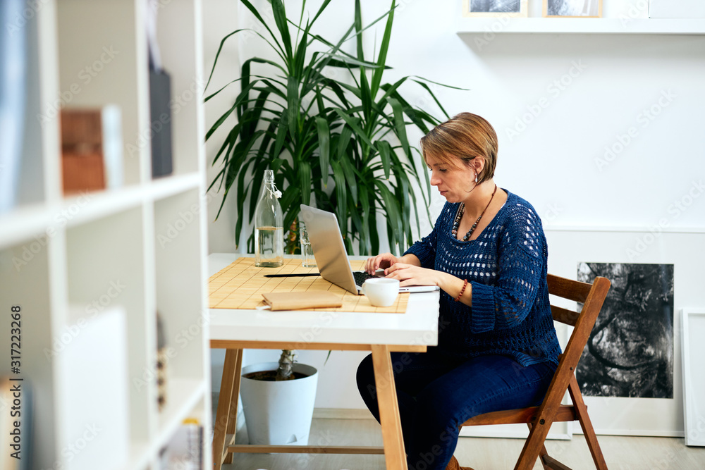 Attractive businesswoman sitting in modern office and typing. Attractive businesswoman sitting in modern office and typing.