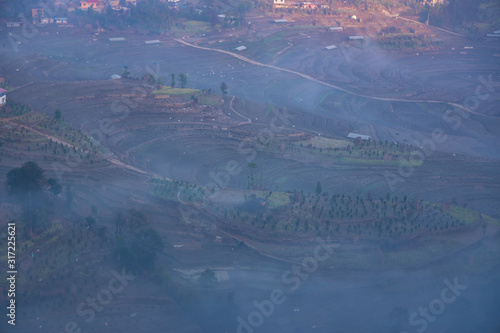 Dramatic Terrace rice farm covered in fog barren after harvest season.