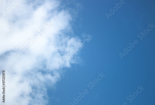 sky is divided into half of the clear blue sky and the beautiful white clouds 