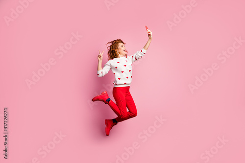 Full length body size view of nice attractive funky lucky cheerful cheery foxy ginger wavy-haired girl jumping taking cell selfie showing v-sign having fun isolated on pink pastel color background