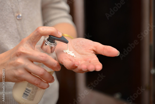 Emollient cream from a bottle on a girl s hand