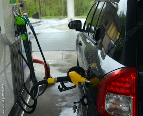 refilling up gas tank of the car with green eco fuel on a filling station