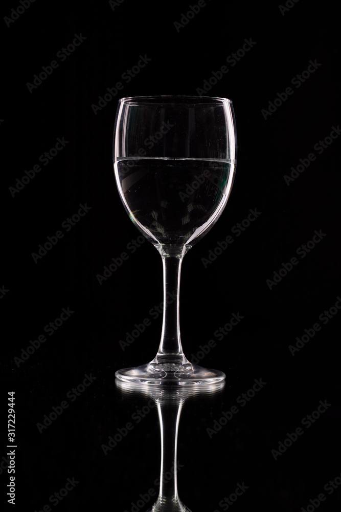 wine glass on a black background with contour lighting. Studio shot.