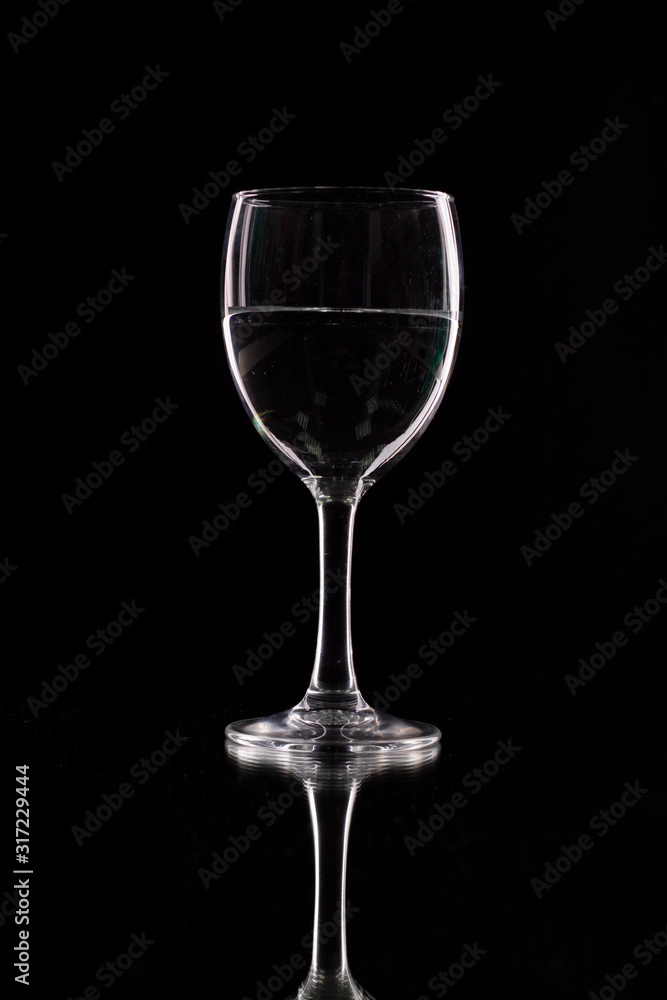 wine glass on a black background with contour lighting. Studio shot. wine glass on a black background with contour lighting. Studio shot.
