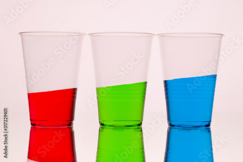 three glasses with liquid of different colors tending to the top. Suitable for banner or infographic.