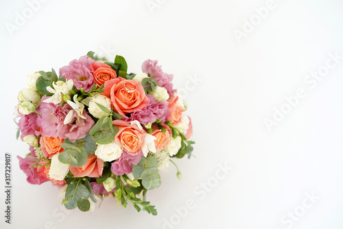 Golden wedding rings on wedding flowers on white background with a copy space