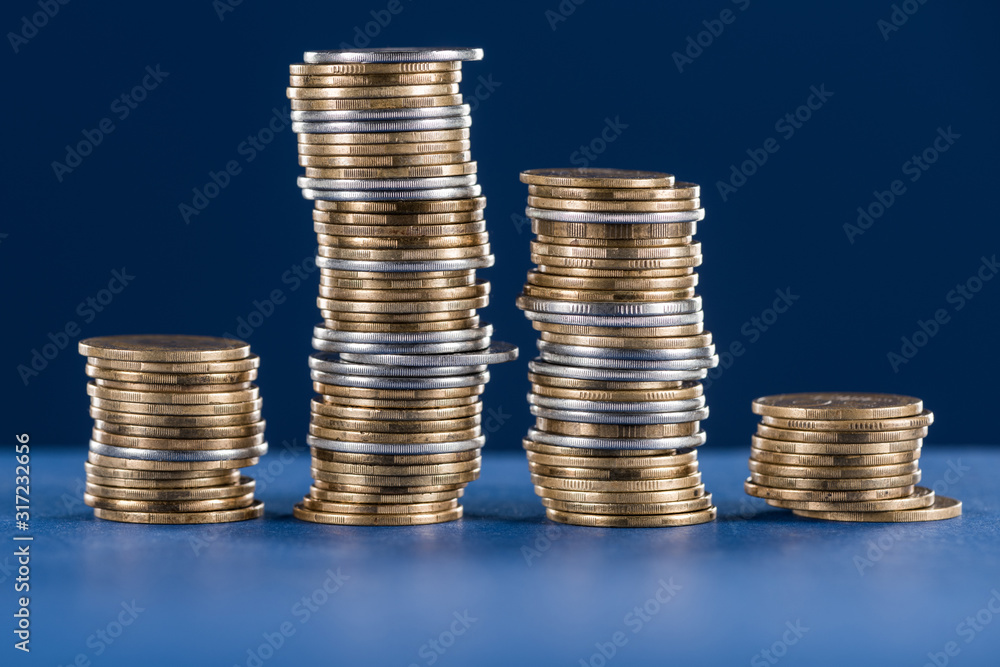 stacks of metal silver and golden coins on blue background stacks of metal silver and golden coins on blue background