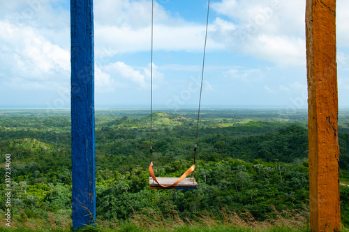 Children swing on the top of green mountain