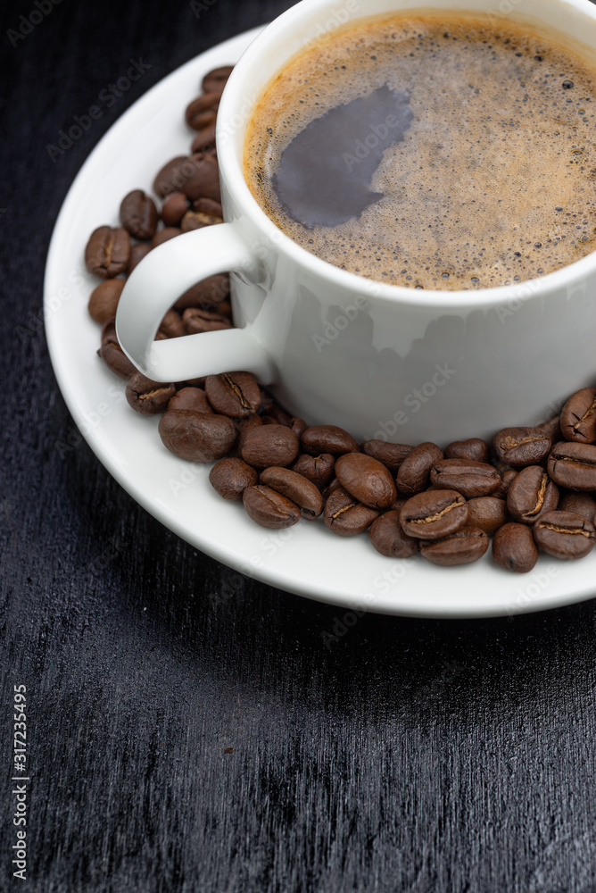 Coffee cup and saucer on a wooden table. Dark background. Coffee cup and saucer on a wooden table. Dark background.