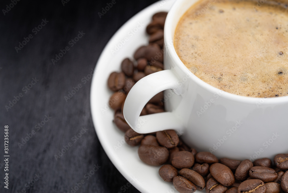 Coffee cup and saucer on a wooden table. Dark background. Coffee cup and saucer on a wooden table. Dark background.