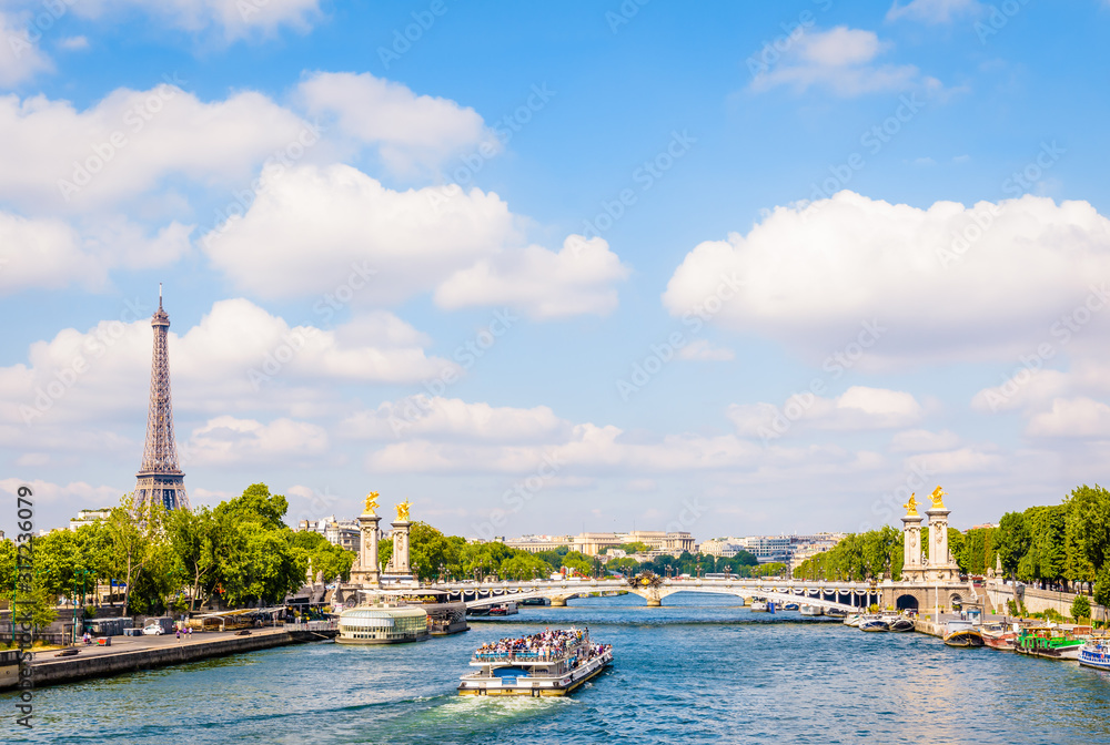 Cityscape of Paris, France, with a bateau-mouche cruising on the river Seine, the Alexandre III bridge, the Eiffel tower on the left and the Chaillot palace in the distance by a sunny summer day. - obrazy, fototapety, plakaty 