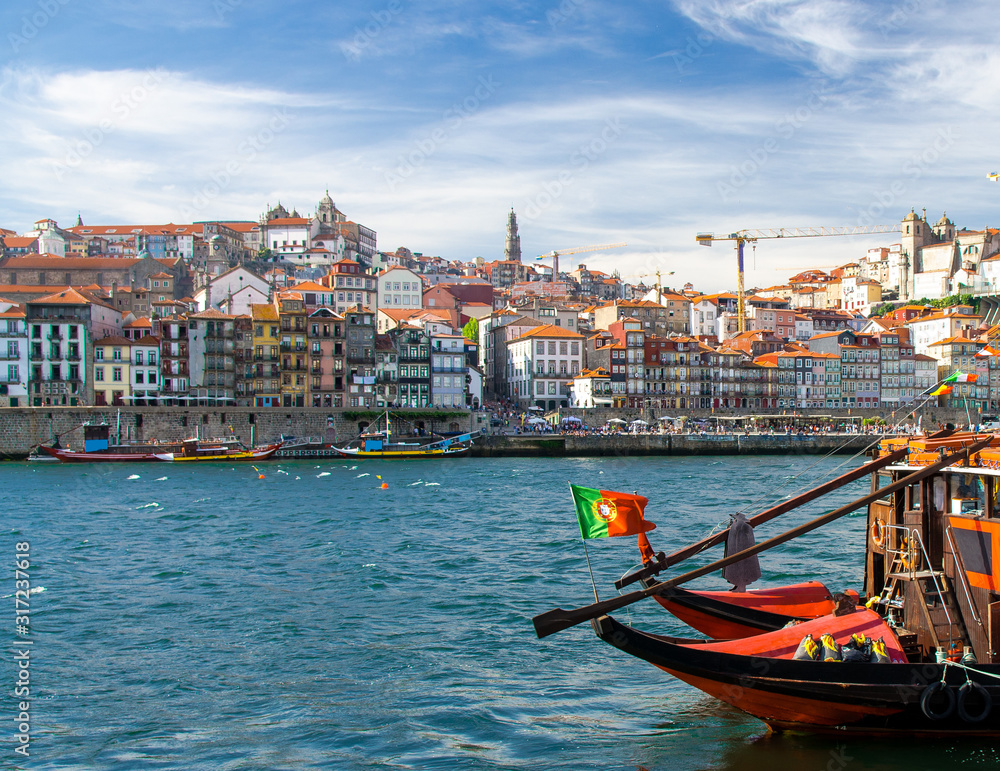 Portugal, Porto, colored houses of old town in Porto, colorful boats on Douro river, Porto by river, Porto old town view, red wooden boats on the river, portuguese flag on karma boat