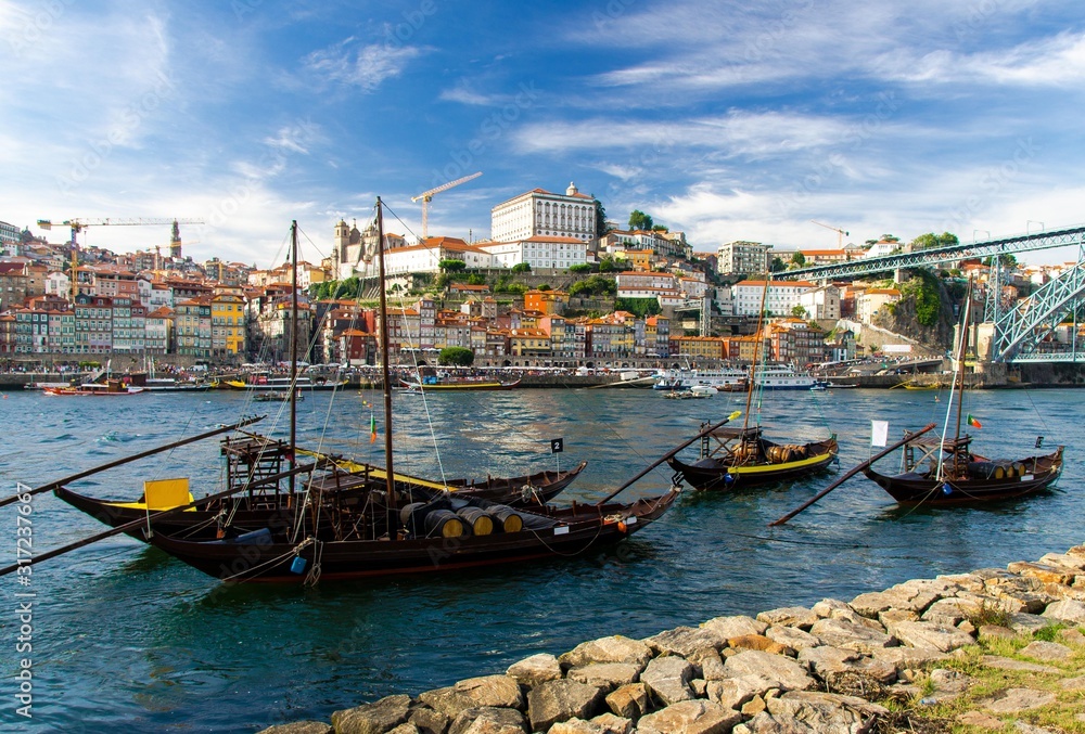 Portugal, city landscape Porto, wooden boats with wine port barrels close up on Douro, panoramic view of the old town Porto,  The Eiffel Bridge view, Ponte Dom Luis, Porto in summer, colored houses