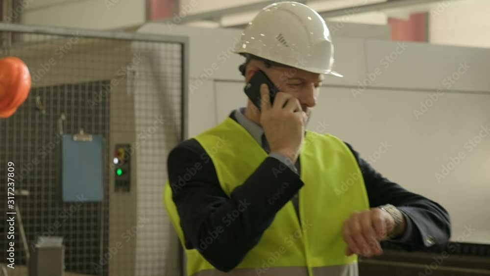 Engineer talking on the phone at factory workshop Engineer talking on the phone at factory workshop