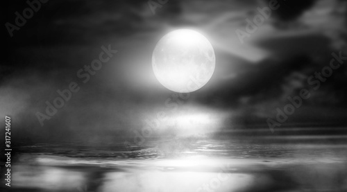 Dramatic black and white background. Cloudy night sky, moonlight, reflection on the pavement. Smoke and fog on a dark street at night. © MiaStendal