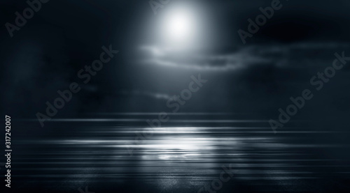 Dramatic black and white background. Cloudy night sky, moonlight, reflection on the pavement. Smoke and fog on a dark street at night.