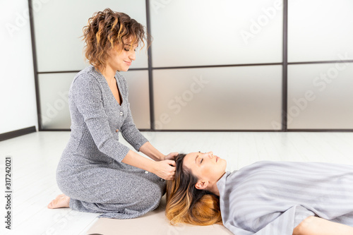 Wellness healthy concept. Meditation of two women on the floor. Relax and zen in the white room. Body care