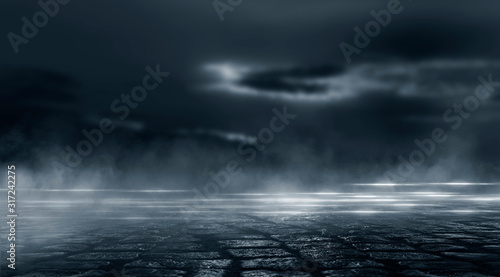 Dramatic black and white background. Cloudy night sky  moonlight  reflection on the pavement. Smoke and fog on a dark street at night.