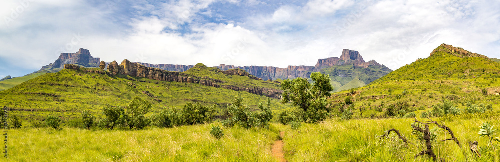 Naklejka premium Panorama of the Amphitheatre and a hiking trail to Policeman's Helmet, Drakensberg mountains, Royal Natal National Park, South Africa
